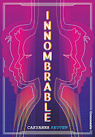 El título, Innombrable, aparece en vertical en el centro con relieve blanco y otros colores, como rosa, azul o amarillo. El nombre de la autora, Caryanna Reuven, aparece abajo en horizontal, en blanco y azul. A izquierda y derecha hay varios perfiles de personas, que no se pueden identificar como mujeres, hombres ni personas no binarias. Cada perfil tiene rasgos diferentes. Predominan los colores rosa, azul y morado. La estética es muy rollo neón, de ciencia ficción clásica o de videojuegos antiguos.