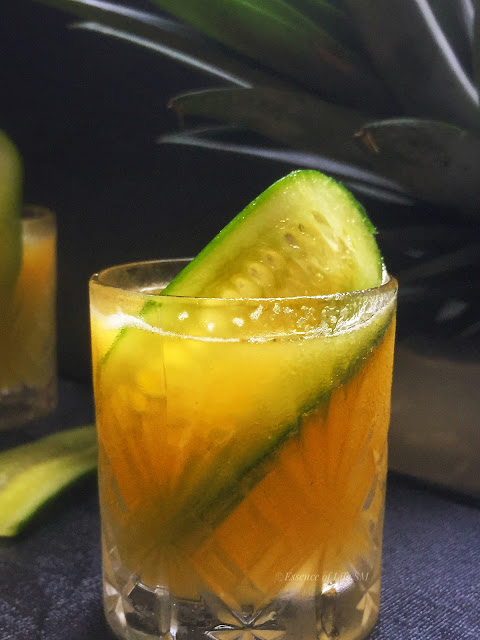 "A refreshing pineapple and cucumber detox drink in a glass."