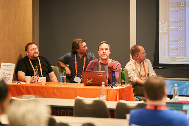 picture of four men sitting behind conference table