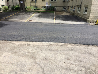 Photograph. Side view of a freshly paved alleyway.