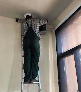 Knocking out dead plaster into a bucket