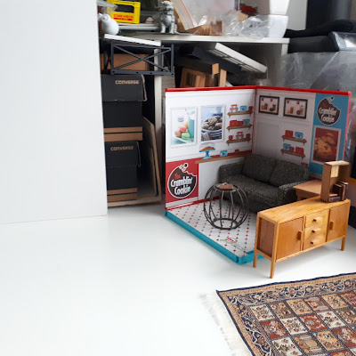 Work table with a one-twelfth scale corner roombox containing a sofa, a side table and a coffee table.