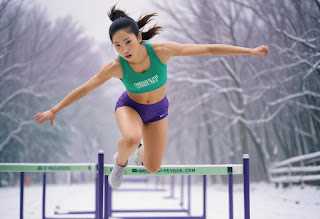 Person jumping over hurdles on a track, representing overcoming setbacks and challenges."
