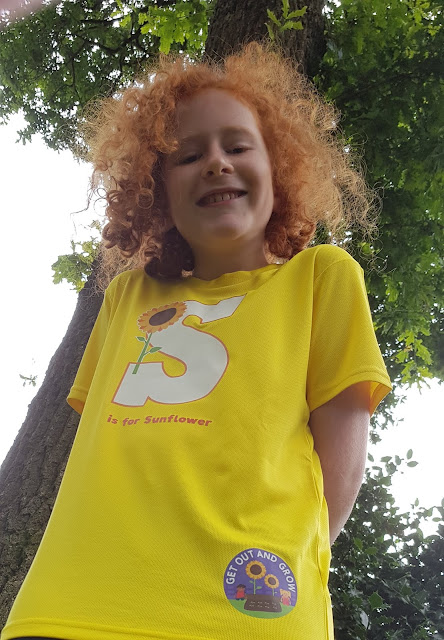 Photo of 10 year old boy in front of huge oak tree with sunflower t-shirt