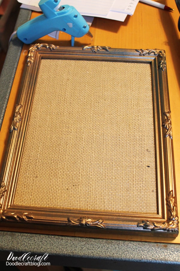Then hot glue the burlap covered cardboard right inside the picture frame so it is firm and secure.