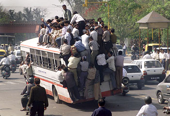 foto de um ônibus transportando passgeiros em todos os lados e em cima na Índia