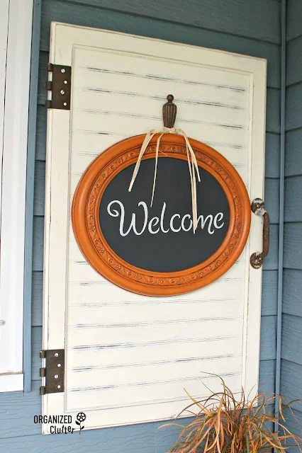 Photo of a mirror upcycled as a pumpkin welcome sign.