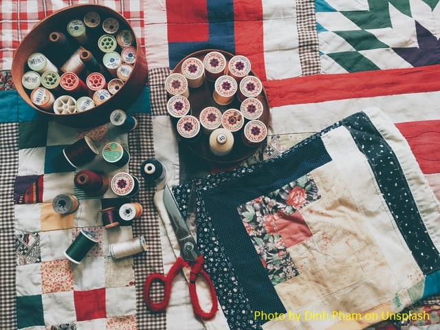 Colcha feital com retalhos, patchwork, e carretéis de linha