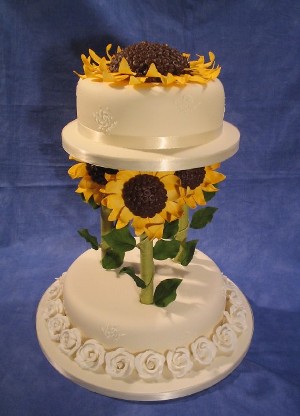 Two tier wedding cake with sunflower topper and sunflower columns separating