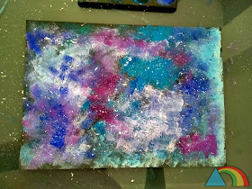 Galaxia hecha con pintura azul y lila aplicada con esponja, y salpicaduras de pintura blanca