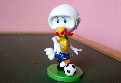 Brinquedo bobble head do Peru da Sadia com camisa da seleção, jogando futebol sobre uma base verde - 7,5cm de altura R$ 15,00