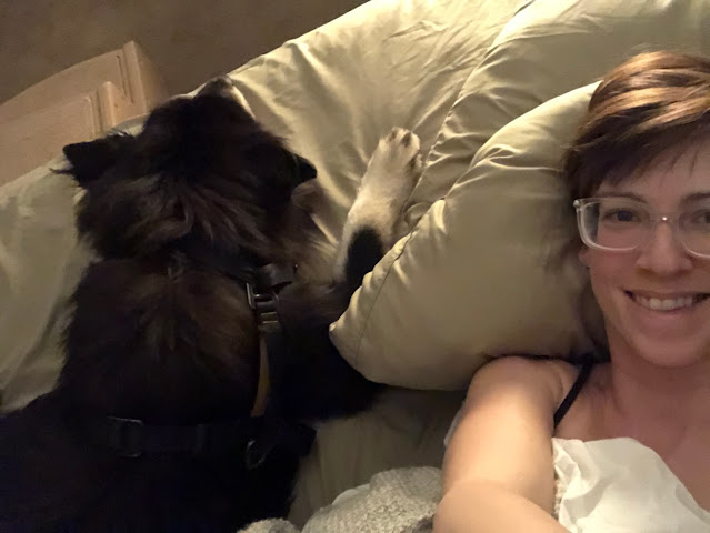 woman and fuzzy dog lying down together