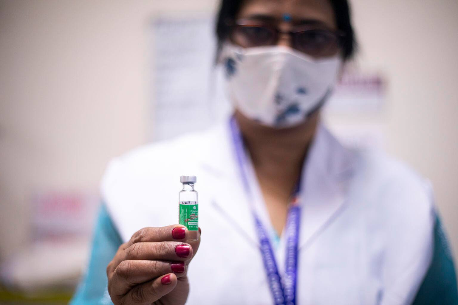 Photo of a woman doctor holding a vial of the COVID-19 vaccination