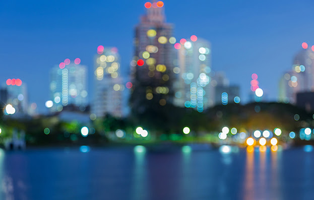 An urban landscape at night that shows lights in office buildings, suggesting people at work.