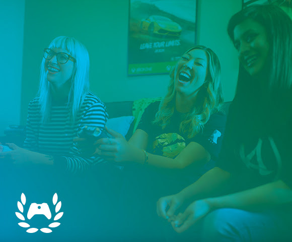 Gamers laughing and playing games from the comfort of their sofa.