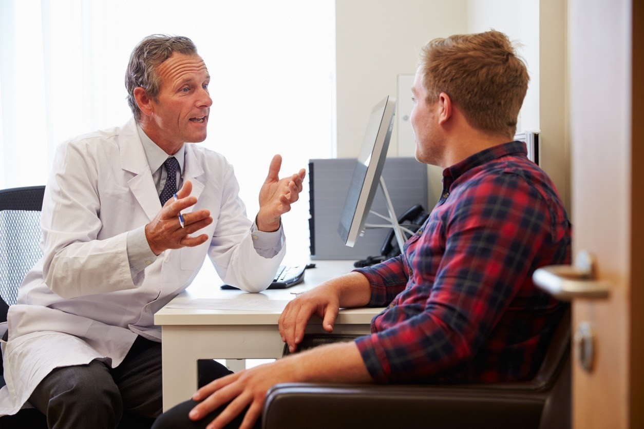 Young adult man consulting with a doctor