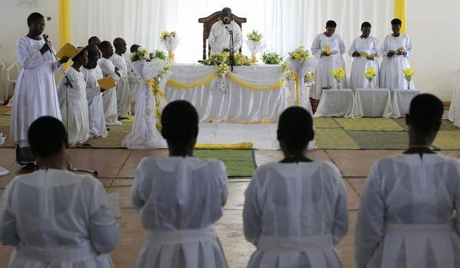 Followers of the Ugandan cult group Faith of Unity, founded by 83-year-old self-professed god Omukama Ruhanga Owobusobozi Bisaka (C), kneel during a prayer session at the cult's headquarters in Kapyemi village in Muhoro town council, 251 km (156 miles) west of the Uganda capital, October 12, 2013. REUTERS-James Akena