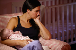 Frustrated mother holding her sleeping baby.