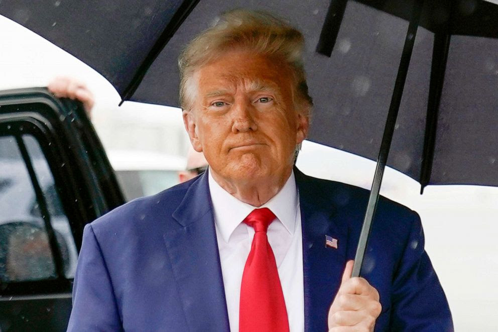 Photo of Donald Trump holding an umbrella.