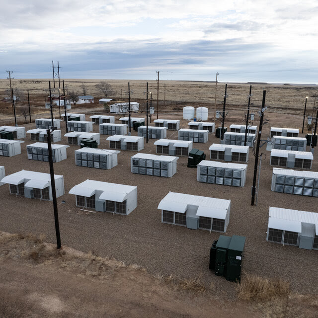 A spare landscape with rows of metallic structures.