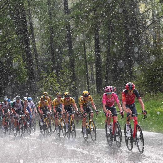 Overall leader INEOS Grenadiers's British rider Geraint Thomas (2ndR) and riders of the pack cycle under pouring rain across the Passo Tre Croci pass in the Dolomites mountains during the nineteenth stage of the Giro d'Italia 2023 cycling race, 183 km between Longarone and Tre Cime di Lavaredo (rifugio Auronzo) on May 26, 2023. (Photo by Luca Bettini / AFP)