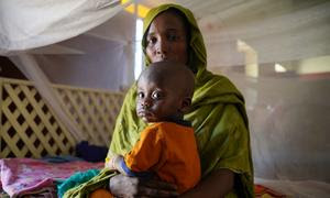 Una madre lleva a su hijo enfermo a un centro de salud apoyado por UNICEF en el norte de Darfur, durante el actual conflicto en Sudán.