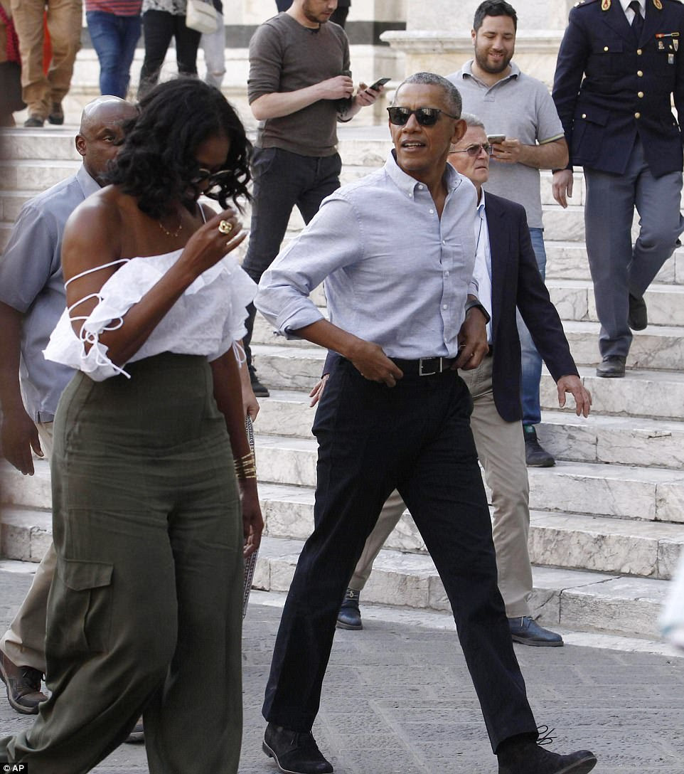 Stylish: Michelle looked especially glamorous as she stepped out in Sienna, Tuscany on Monday wearing a flirty shoulder-baring top, paired with a high-waisted kaki-colored pants