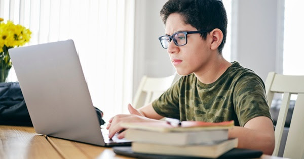 Young boy sitting in front of a laptop