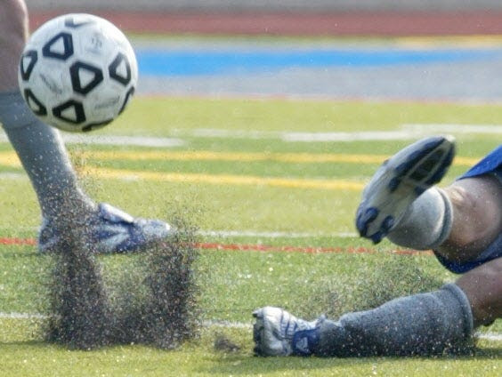 A soccer player kicks up powder from the artificial turf at Sayreville War Memorial High School in East Brunswick, N.J., during a soccer game in 2001.
