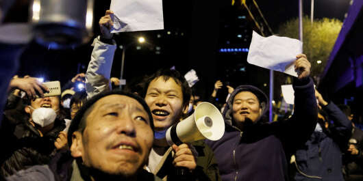 People hold white sheets of paper in protest over coronavirus disease (COVID-19) restrictions after a vigil for the victims of a fire in Urumqi, as outbreaks of COVID-19 continue in Beijing, China, November 28, 2022.