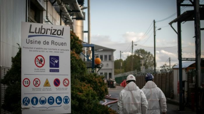 Des agents de sécurité et de nettoyage devant l'usine de Lubrizol