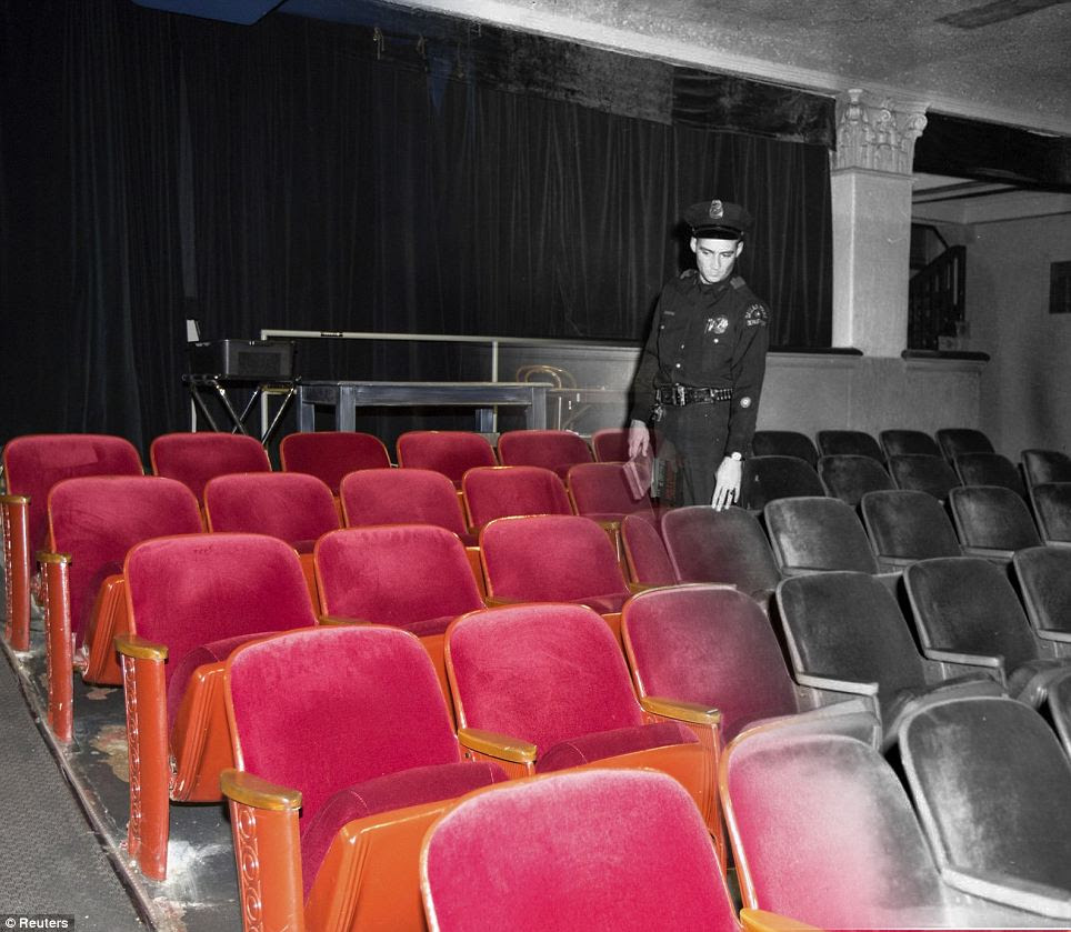 Preserved: A uniformed policeman points to the spot where officers finally caught up with Oswald after Kennedy's assassination