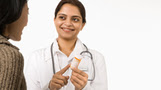 a pharmacist showing pills to patient