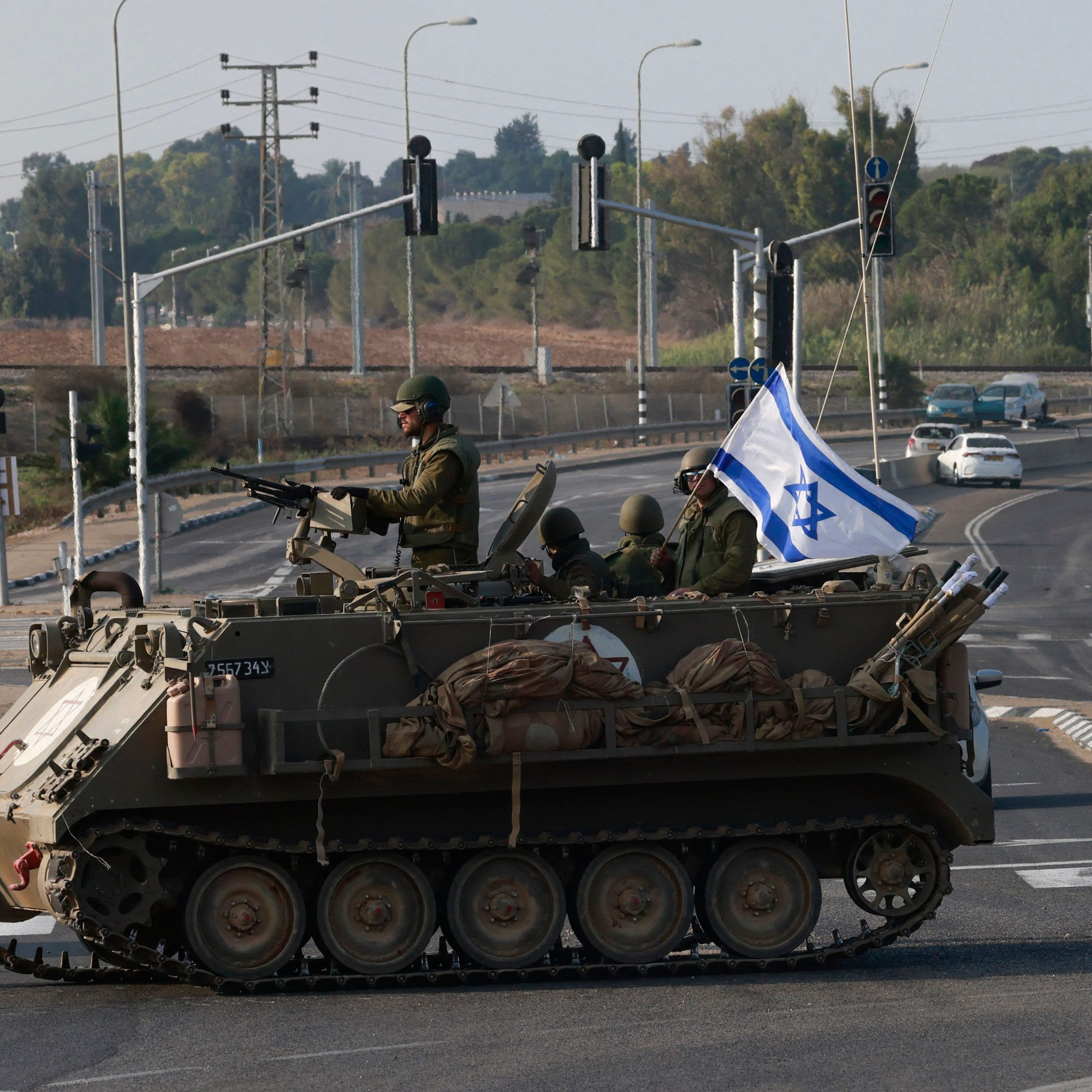 Israeli forces cross a main road in their armoured personnel carrier APC as additional troops are deployed near the southern city of Sderot on October 8, 2023. Photo by MENAHEM KAHANA/AFP via Getty Images