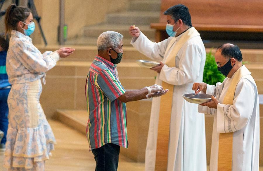 Faithful wear masks and some wear gloves as they receive Communion at the Cathedral of Our Lady of the Angels in downtown Los Angeles, June 7, 2020. (AP Photo/Damian Dovarganes)