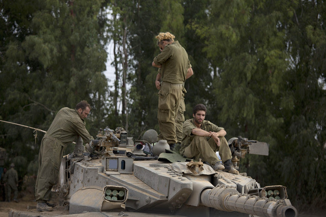 Israeli soldiers work on a tank near the Israel and Gaza border Thursday, July 24, 2014. Israeli tanks and warplanes bombarded the Gaza Strip on Thursday, as...