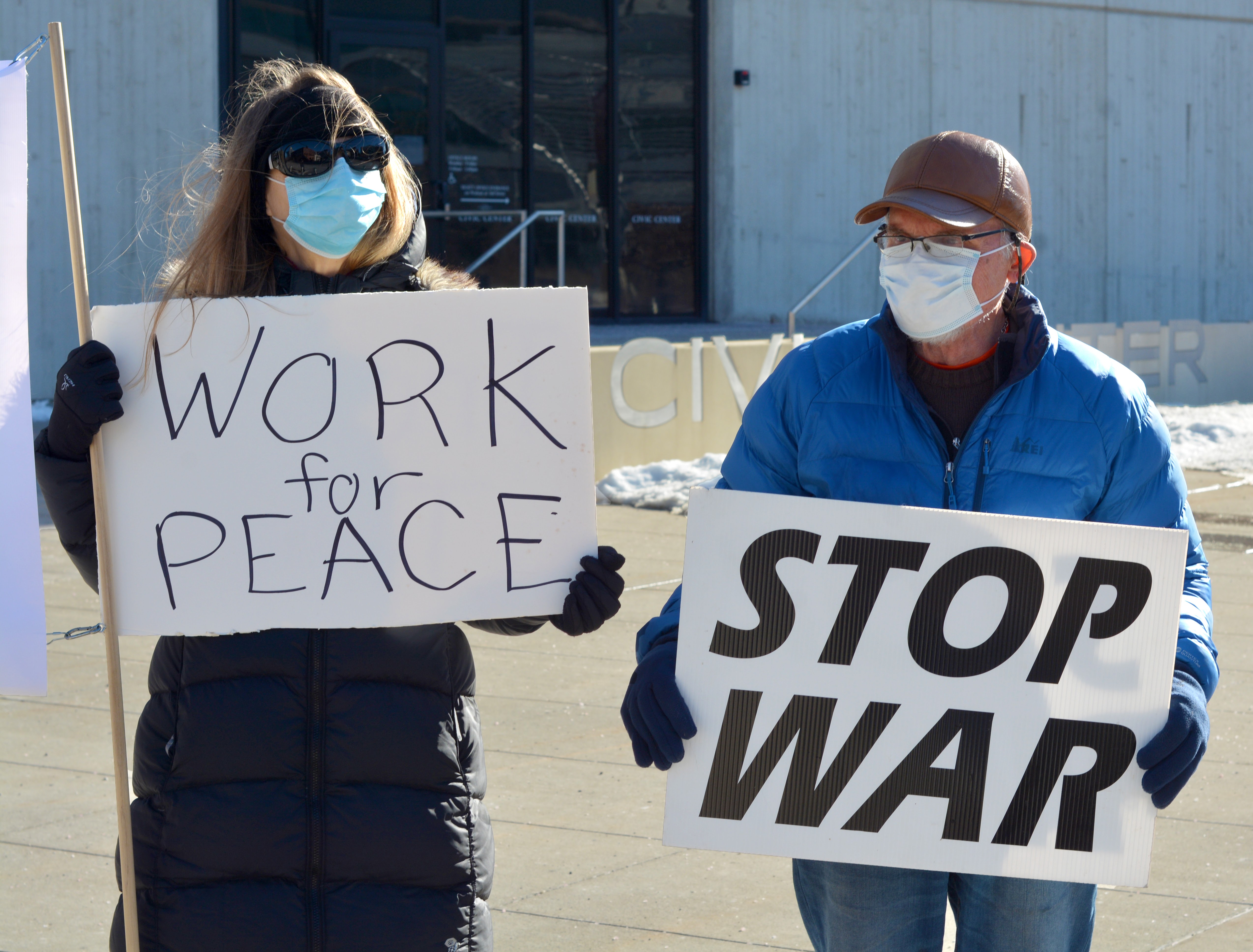 Two people holding anti-war signs.