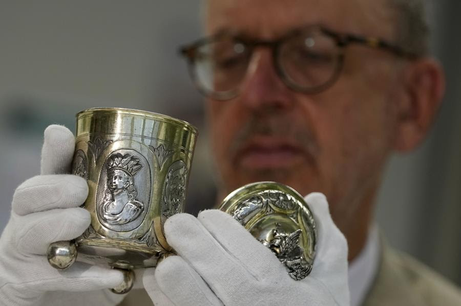 A man examines a silver heirloom that was stolen from a Jewish family by the Nazis.