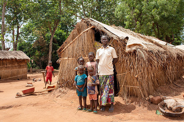 Woman and her four children standing outside their home