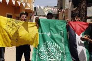Palestinian Authority Arabs wave the flags of two PA factions, Fatah (yellow) and Hamas (green) in support of unity.