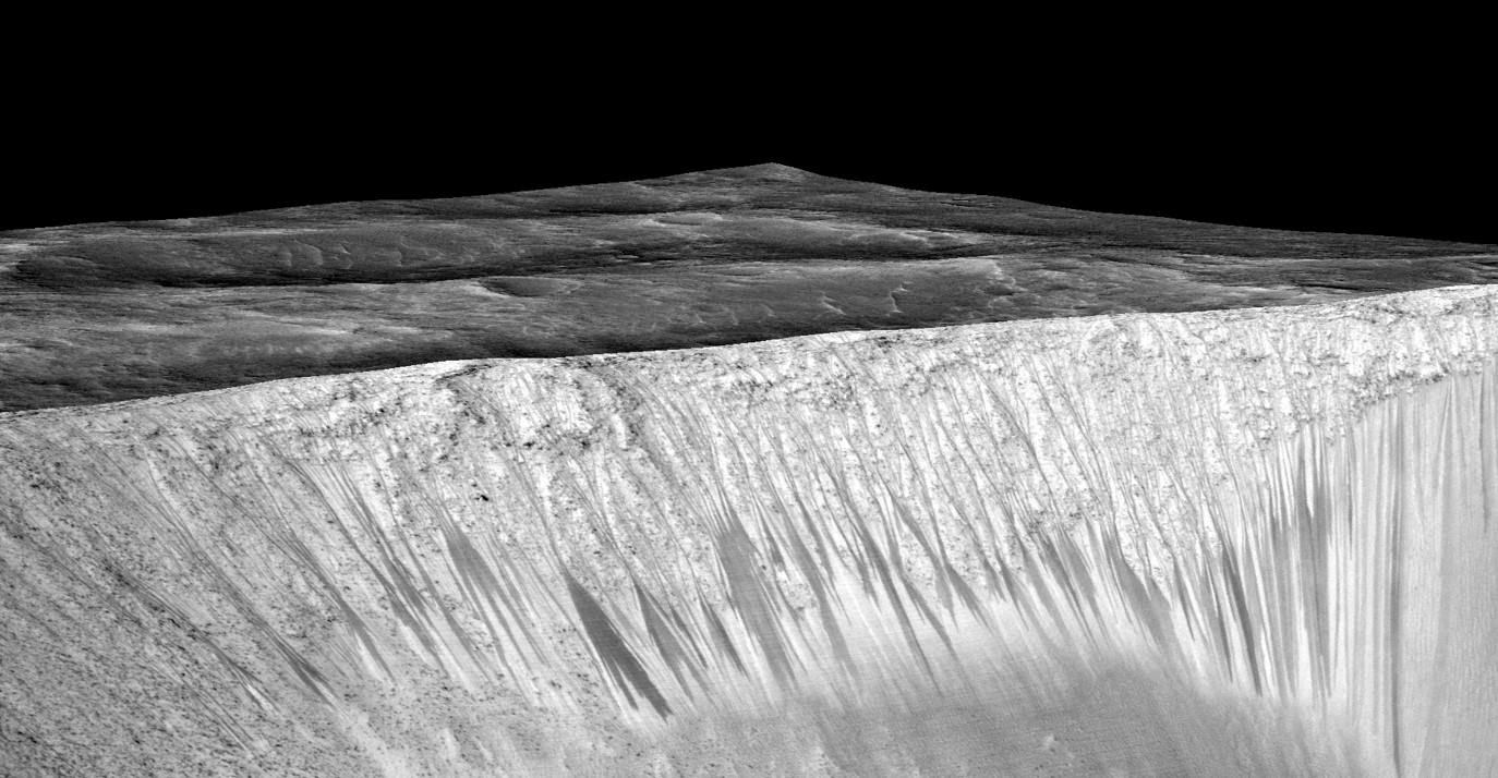 Dark narrow streaks called recurring slope lineae emanating out of the walls of Garni crater on Mars. The dark streaks here are up to few hundred meters in length. They are hypothesized to be formed by flow of briny liquid water on Mars. The image is produced by draping an orthorectified (RED) image (ESP_031059_1685) on a Digital Terrain Model (DTM) of the same site produced by High Resolution Imaging Science Experiment (University of Arizona). Vertical exaggeration is 1.5.    Credits: NASA/JPL/University of Arizona