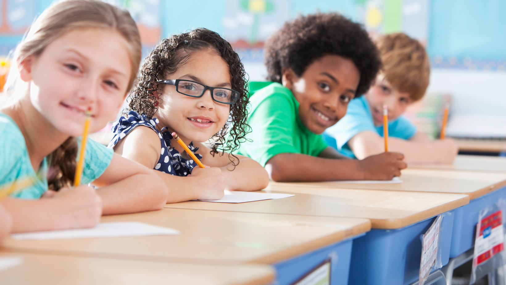 four Children at school writing.