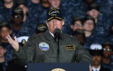 President Donald Trump wears a flight jacket and an admiral's cap aboard the Gerald R. Ford carrier