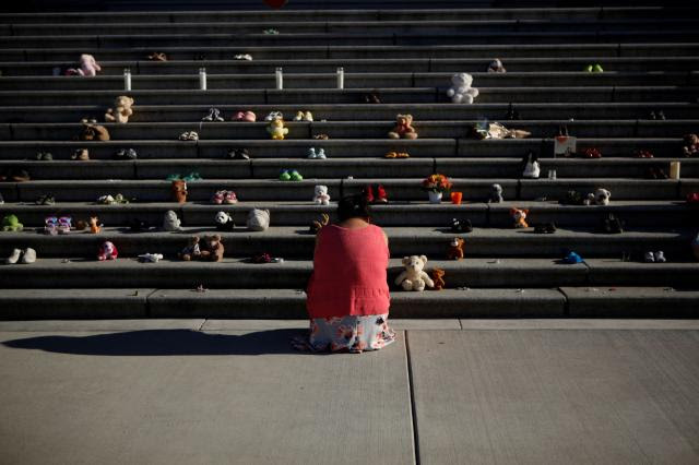 Photo of a member of the Tla-O-Qui-Aht First Nation paying her respects below the steps outside the legislature in Victoria, BC.