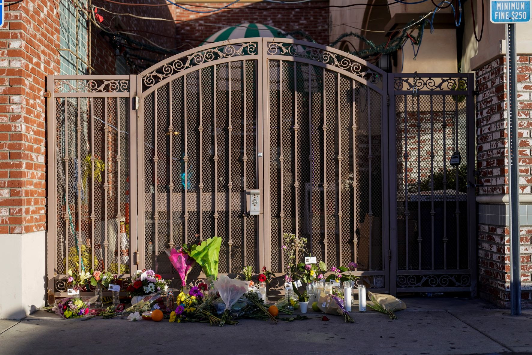 Flowers are placed at the entrance to Star Dance Studio in Monterey Park, Calif., Monday, Jan. 23, 2023.