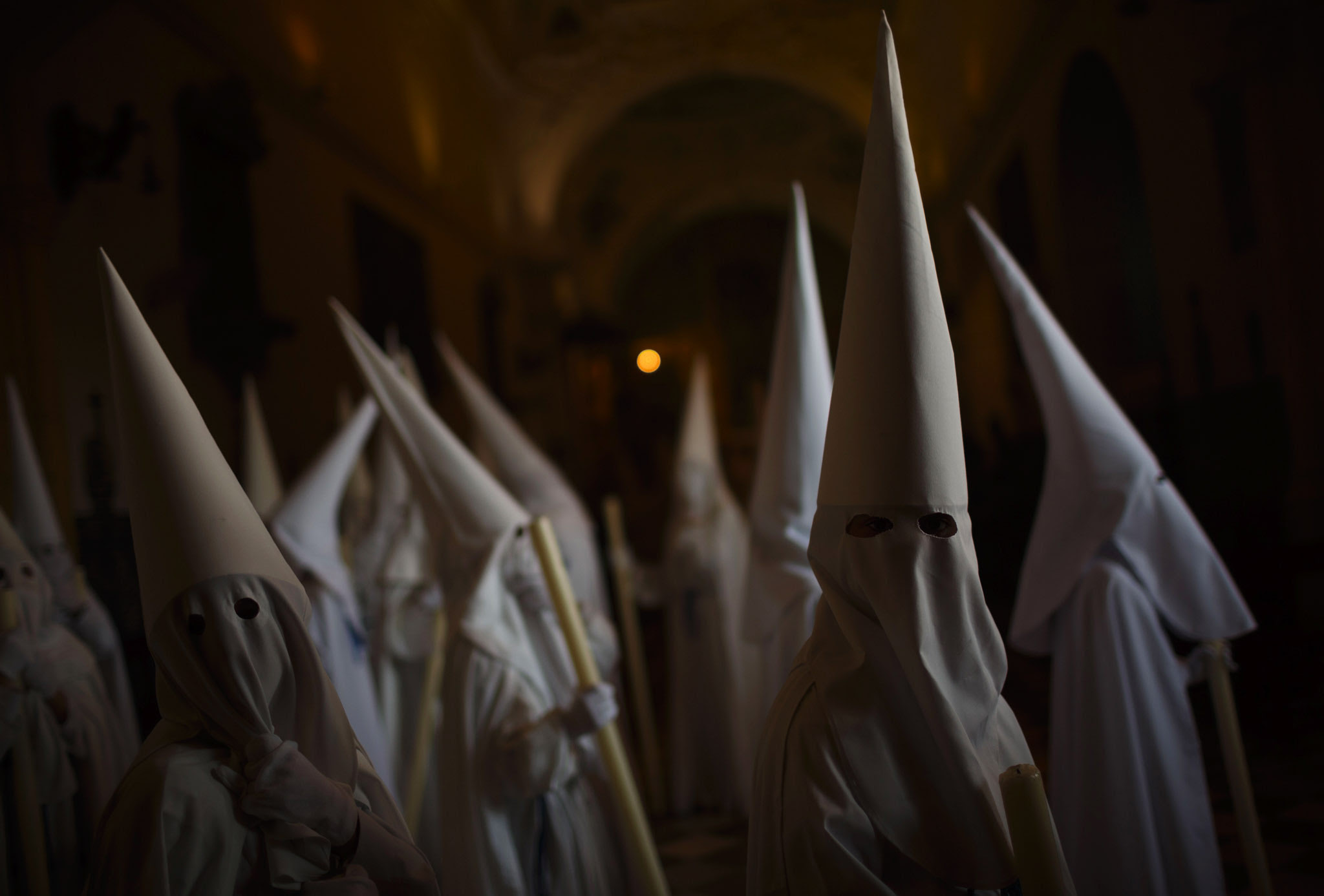 Penitents wait inside San Francisco church to take part in "Nuestro Senor Atado a la Columna, Maria Santisima de la Paz y San Juan Evangelista" Holy Week procession in Arcos de la Frontera, Spain. 