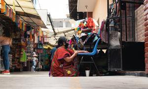 Una mujer sentada trabajando en un mercado en la Ciudad de México, México.