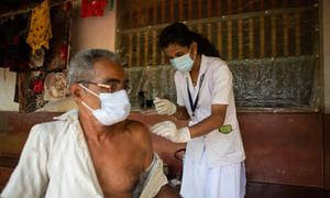 Un trabajador sanitario de la India vacuna a un anciano contra el COVID-19. 