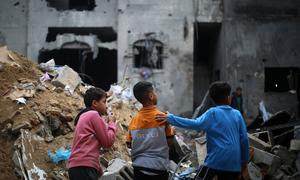 Niños observando la destrucción de viviendas en la ciudad de Rafah, en el sur de Gaza.