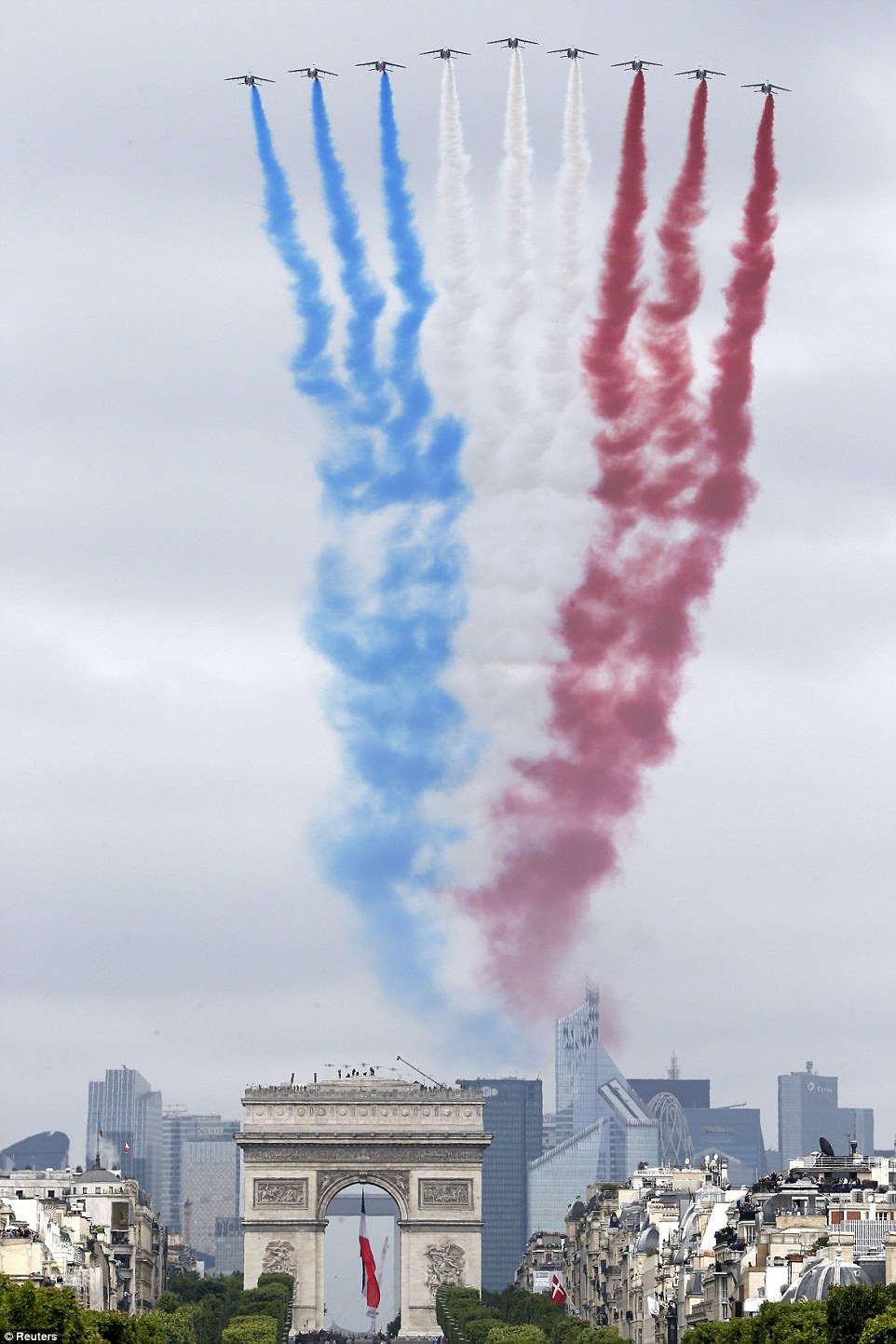 Nine jets form the French Air Force scream over the Arc de Triomphe as part of the celebrations for Bastille Day releasing smoke in the colours of the French flag